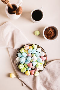 Sweet small meringues for dessert on a plate on the table top and vertical view