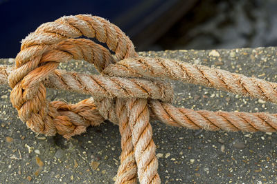 Close-up of rope tied on retaining wall
