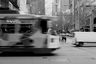 Blurred motion of tram and people walking on street in melbourne city