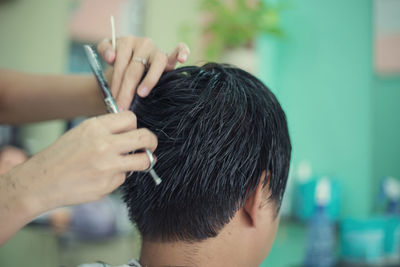 Close-up of man getting haircut