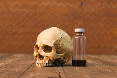 Human skull by bottle on table