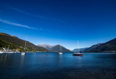 Sailboats in sea against blue sky