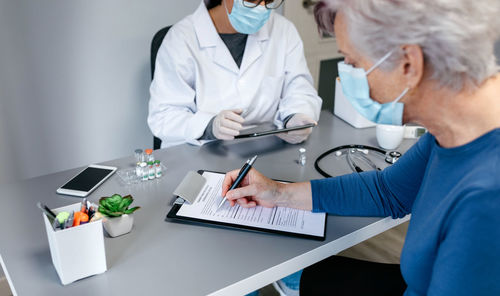 Midsection of doctor examining patient in hospital