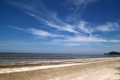 Scenic view of beach against blue sky