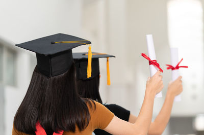 Rear view of women holding certificate