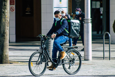 Man riding bicycle on street in city