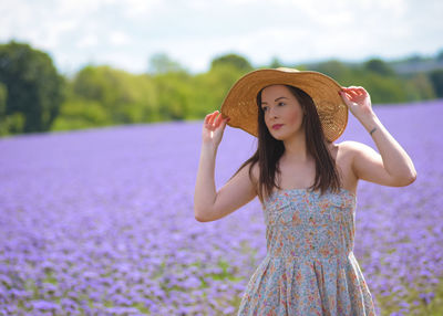 Portrait of beautiful young woman wearing hat standing outdoors