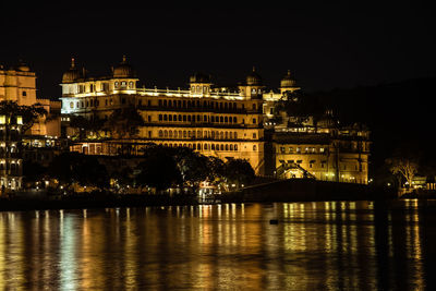 Reflection of illuminated palace building in river