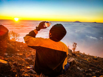 Rear view of man on mountain during sunset