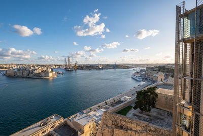 High angle view of city by river against sky