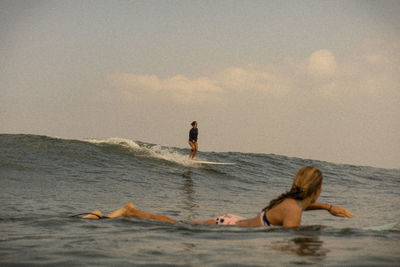 People on sea shore against sky