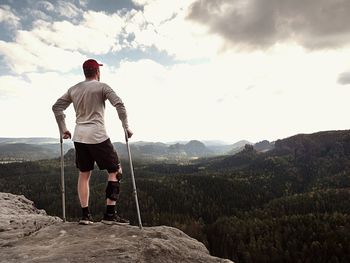 Hiker in t-shirt, medicine crutch and leg fixed in immobilize.  man has broken leg in immobilizer 