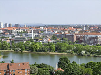 Scenic view of river by buildings against clear sky