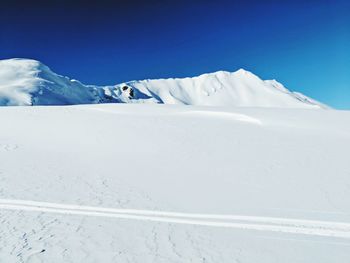 Scenic view of snowcapped mountains against blue sky