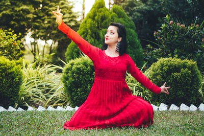 Young woman with red leaves in park