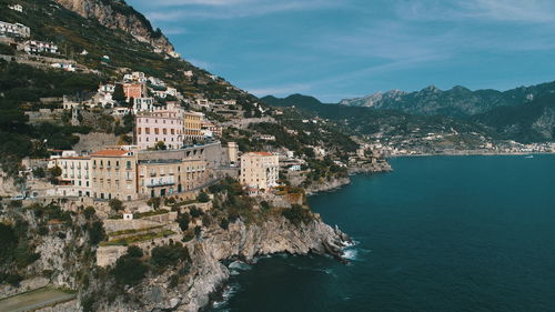 Aerial view of town by sea against sky