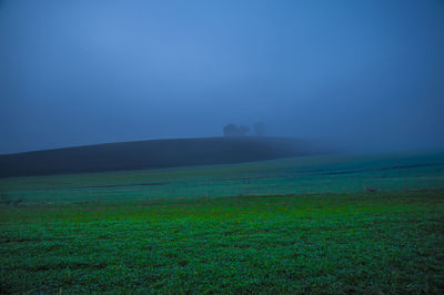 Scenic view of field against sky during foggy weather