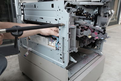 Cropped hand of man repairing machine in workshop