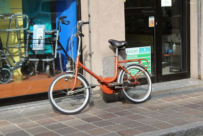 Bicycle parked on street by building