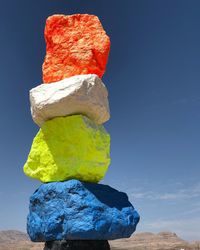 Close-up of stone stack on rock against sky