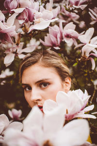 Close-up portrait of woman with pink flowers