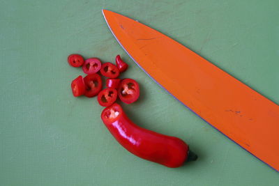 High angle view of red chili peppers with knife on table