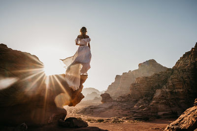 Low angle view of woman against clear sky