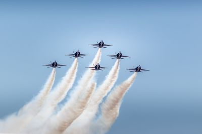 Low angle view of airplane flying against clear blue sky