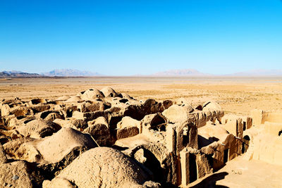 Scenic view of desert against clear blue sky