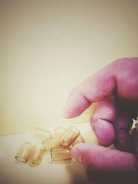 Close-up of person holding hands over white background