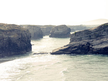 Scenic view of sea and mountains against clear sky