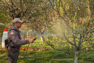 Man spraying insecticide on plants