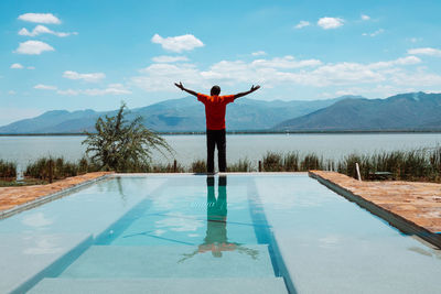 A man standing on a infinity swimming pool at lake jipe at tsavo west national park in kenya