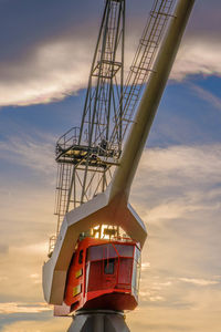 Low angle view of a harbour crane against sky at sunset