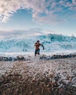 Full length of man standing on beach against sky