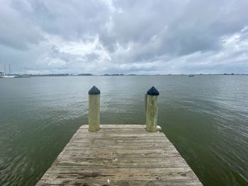 Wooden pier over sea against sky