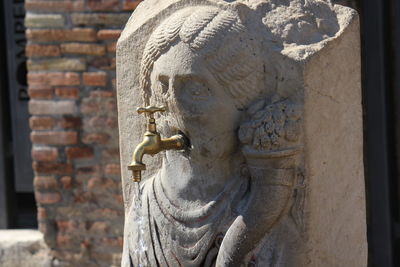 Close-up of buddha statue against wall