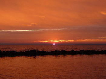 Scenic view of sea against orange sky