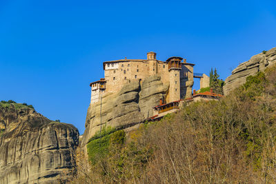 Low angle view of old ruins against clear blue sky