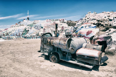 Abandoned truck on field against sky