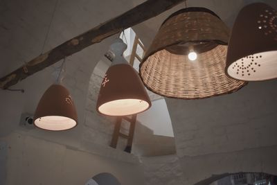Low angle view of illuminated pendant light hanging from ceiling