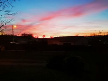 Silhouette buildings against sky at sunset