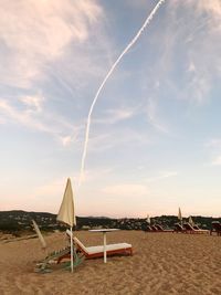 Lifeguard hut on beach against sky during sunset