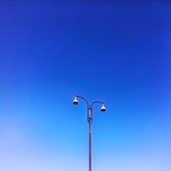 Low angle view of street light against clear blue sky