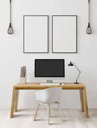 Empty chairs and table against white wall