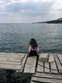 Woman looking at sea against sky