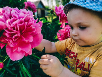 Close-up portrait of boy with pink flowers