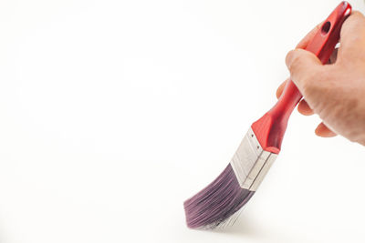 Close-up of hand holding flag against white background