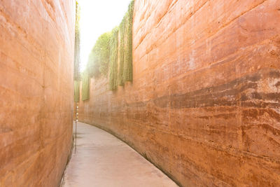 Walking path between the reddish earthen walls.