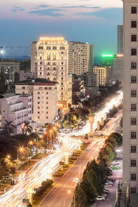 High angle view of city street amidst buildings against sky